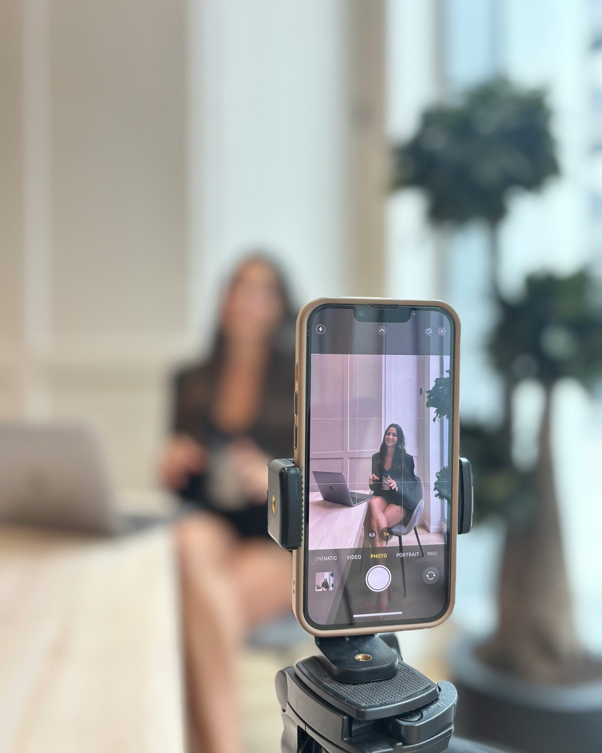 A creator filming a video on a phone mounted to a tripod